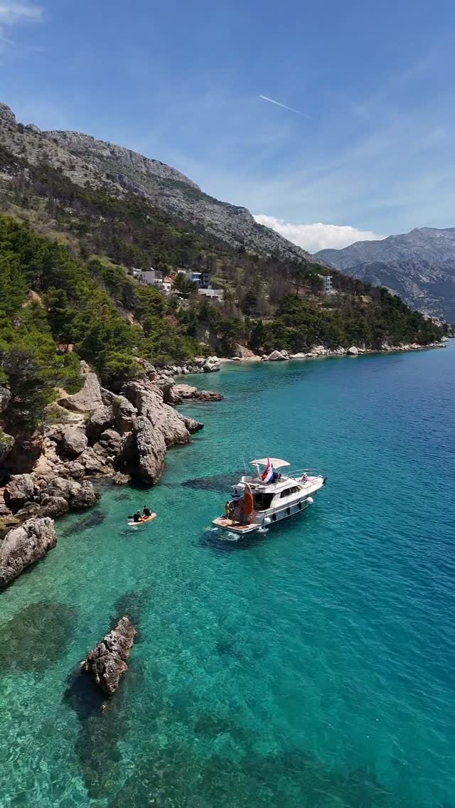 Providenca anchored in a turquoise bay beneath the Dalmatian mountains