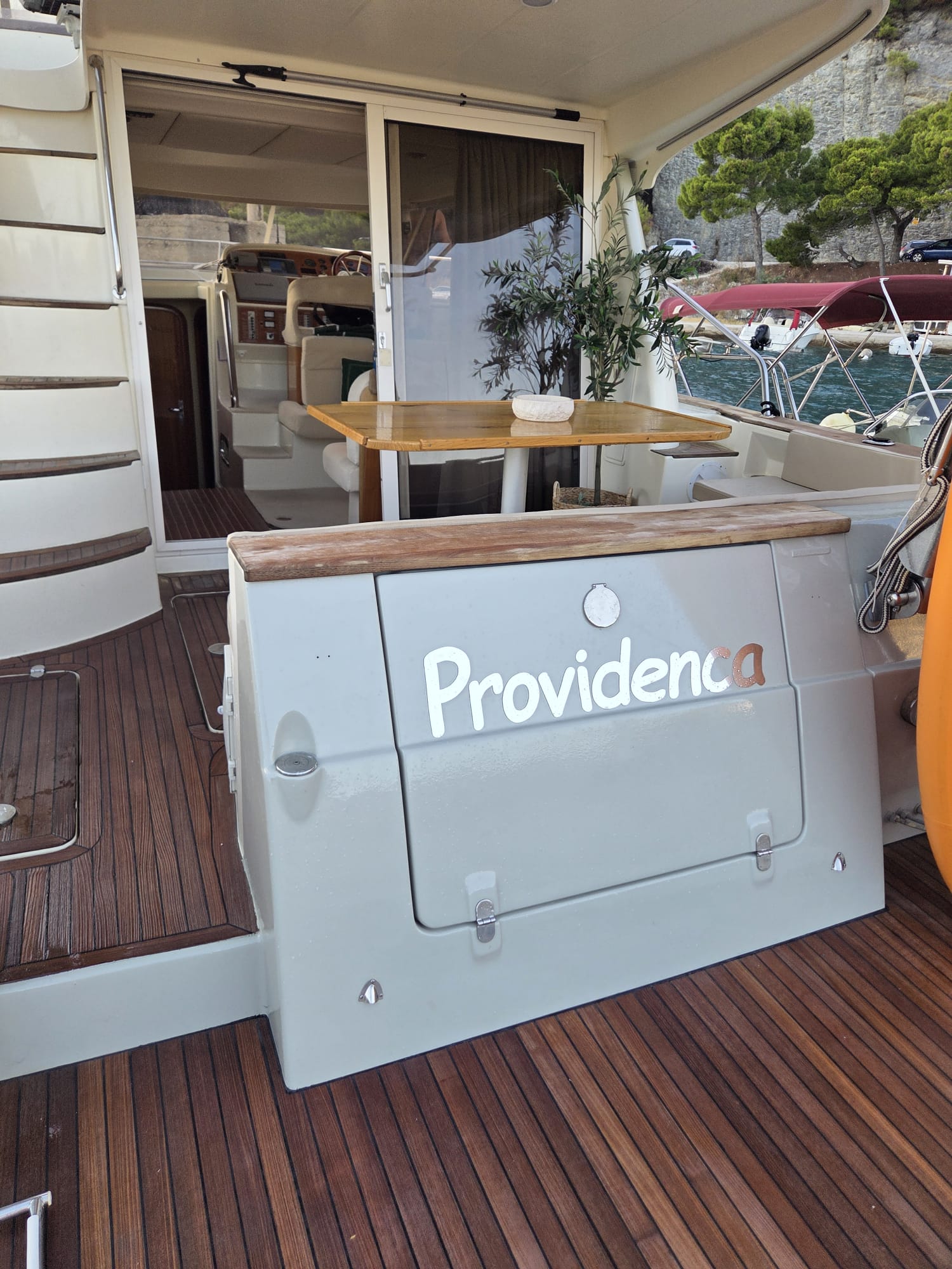 The Providenca name plate on the aft deck, with the shaded cockpit dining table behind